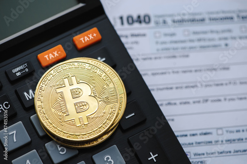 Bitcoin taxation or cryptocurrency concept with US tax form 1040 in Individual Income Tax Return. photo