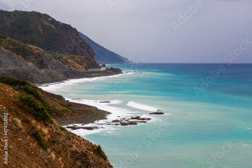 Fototapeta Naklejka Na Ścianę i Meble -  The coast of Samandag, where the Amanos mountains meet the Mediterranean Sea. The shores of Turkey's Hatay city, Samandag district. The impressive colors of the Mediterranean from green to blue.