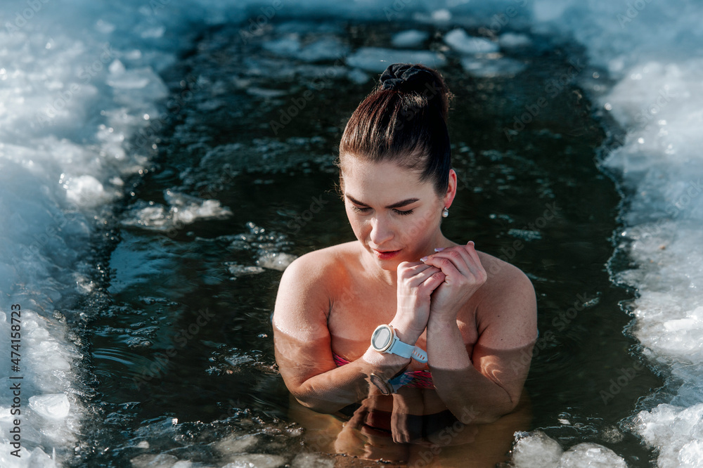 Girl with bikini and a watch in frozen lake ice hole. Woman hardening the  body in cold water. Good immunity is protection against many diseases.  Vintage color filter Stock Photo | Adobe