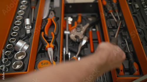 Hand takes a screwdriver from the toolbox