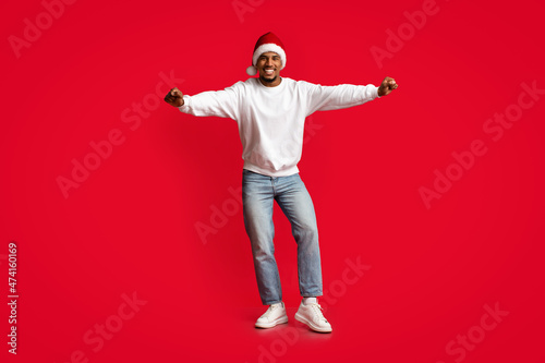 Joyful african american guy in Santa hat having fun © Prostock-studio