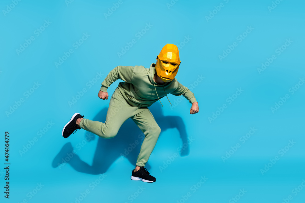 Obraz premium Photo of funky hurry positive energetic weird guy prepare run wear gorilla mask sportswear isolated blue color background