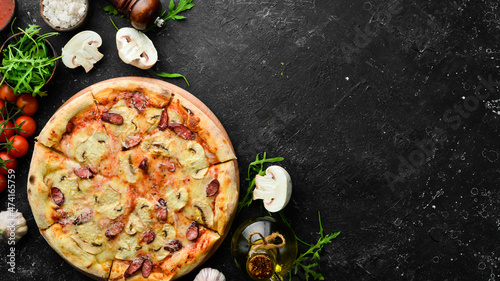 Homemade Pizza with sausages, mushrooms and cheese. On a black stone background. Free space for text.
