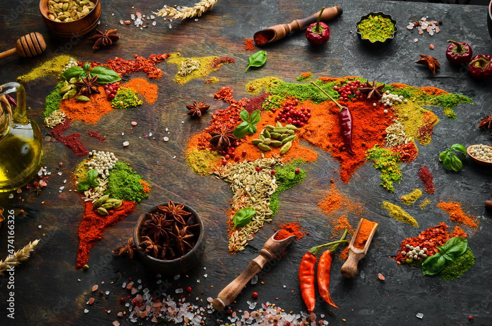 Spice banner. The map of the world is made of various spices and seasonings on a dark background. Top view. - obrazy, fototapety, plakaty 
