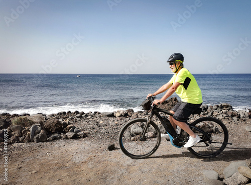 Senior man outdoors biking at sea enjoying freedom and healthy lifestyle