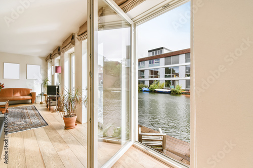 Fotografering Lovely living room with an open door overlooking the boathouse