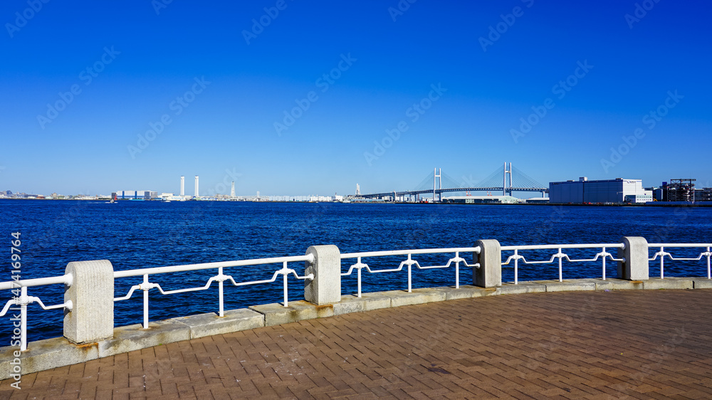 横浜の山下公園　海際の白い手摺から横浜港に架かるベイブリッジを一望（神奈川県横浜市）