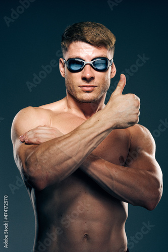 sports man with naked torso swimmer professional dark background