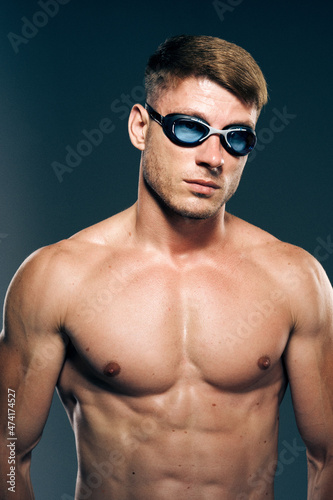 sports man with naked torso swimmer professional dark background © VICHIZH