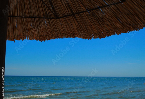 Fototapeta Naklejka Na Ścianę i Meble -  Reed umbrella by the sea

