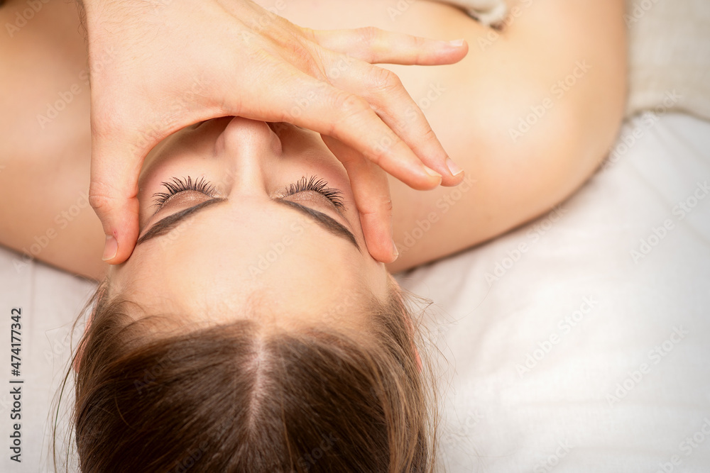 Face massage with fingers of a masseur. Female facial skin care at a beauty spa salon