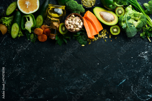 The set of foods rich in vitamin E  pumpkin  broccoli  dried apricots  parsley  avocado and vegetables. Top view. Rustic style.