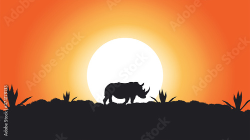 Abstract vector painting of a rhino standing in a savanna, sunset and orange-red sky, rays of the sun © Дмитрий Петухов