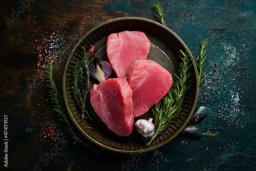 Quadro em tela Raw tuna steak with rosemary. On a dark background. Flat lay.
