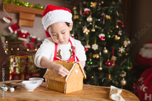 young girl making gingerbread house at home