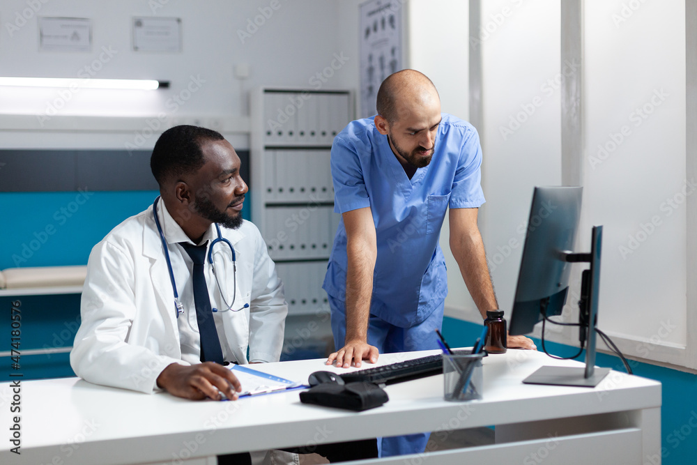 Obraz premium Team of medical therapists monitoring sickness symptoms expertise on computer discussing healthcare treatment. African american physician doctor working at medicine prescription in hospital office