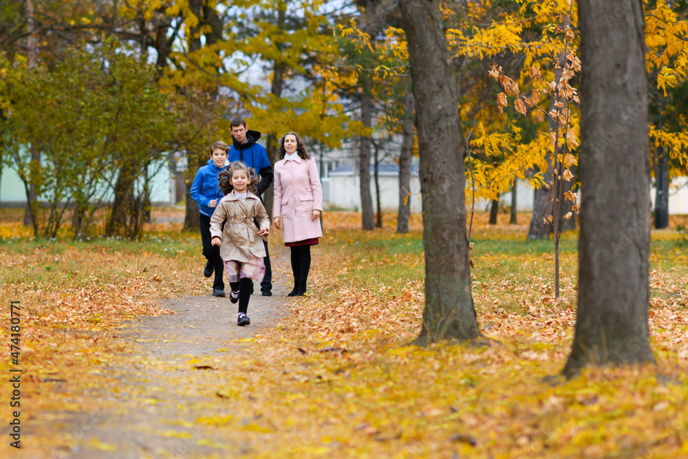 Children run along path in autumn park. They play and laugh, they have a lot of fun. Beautiful nature and trees with yellow leaves. Children run along path in autumn park. They play and laugh, they have a lot of fun. Beautiful nature and trees with yellow leaves.