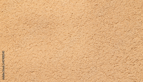 Texture of a wall of peach color stucco paint