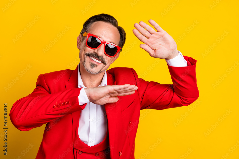 Portrait of good looking middle age male dancing fooling around wear red costume isolated on yellow color background Portrait of good looking middle age male dancing fooling around wear red costume isolated on yellow color background