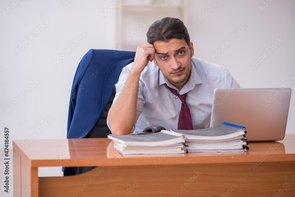 Young businessman and too much work in the office Young businessman and too much work in the office