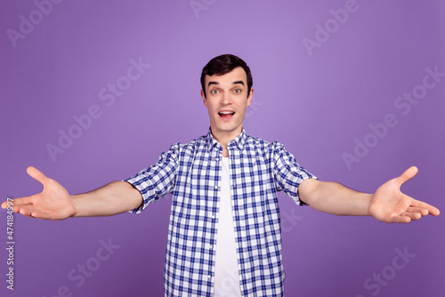 Photo of young cheerful man good mood open arms welcome invite isolated over violet color background