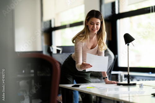 Young businesswoman in office organizing documents.