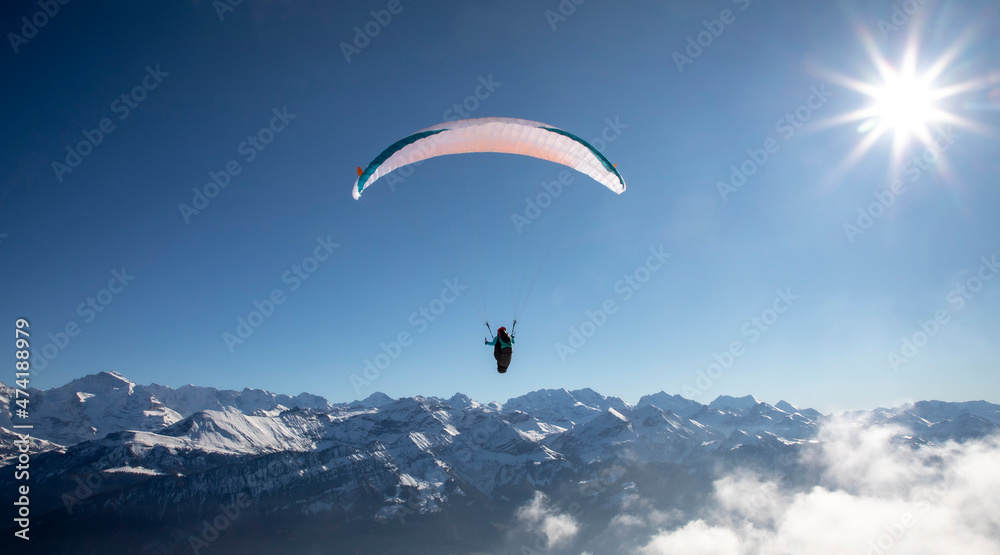 paraglider in the bernese alps.In the background mountain peaks of Eiger, Moench and Jungfrau, Switzerland paraglider in the bernese alps.In the background mountain peaks of Eiger, Moench and Jungfrau, Switzerland