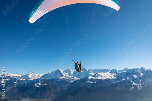 paraglider in the bernese alps.In the background mountain peaks of Eiger, Moench and Jungfrau, Switzerland © Lunghammer