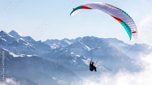 paraglider in the bernese alps.In the background mountain peaks of Eiger, Moench and Jungfrau, Switzerland