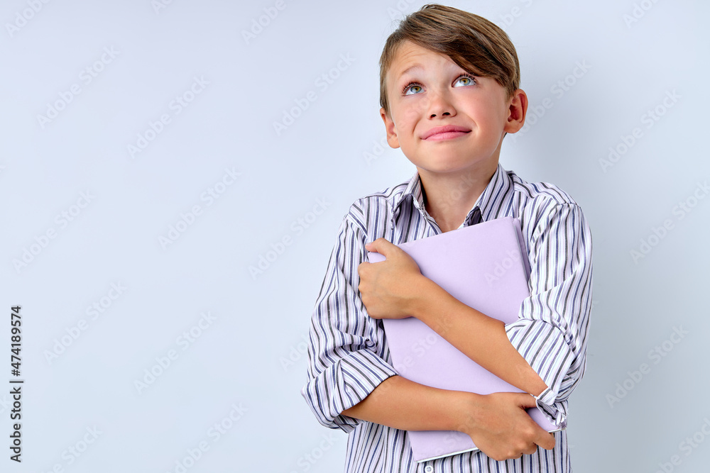 Dreamy Child boy hug Book Has Good Idea on white studio Background, looking up with Copy Space. Happy caucasian Kid Go Back to School. Success, Winner, Genius, Superhero concept Dreamy Child boy hug Book Has Good Idea on white studio Background, looking up with Copy Space. Happy caucasian Kid Go Back to School. Success, Winner, Genius, Superhero concept