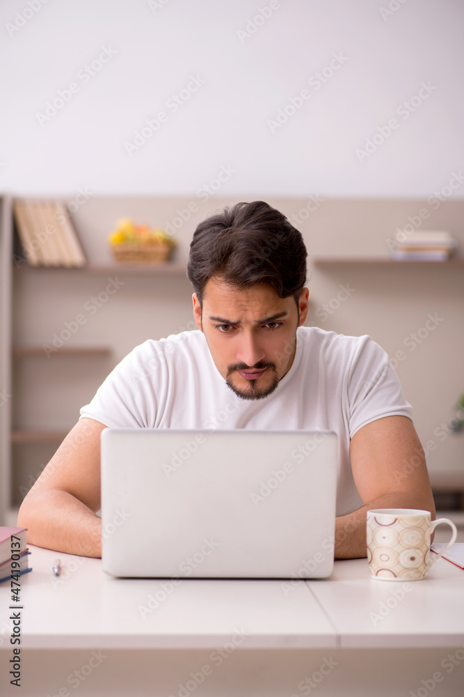 Young male student studying at home during pandemic Young male student studying at home during pandemic