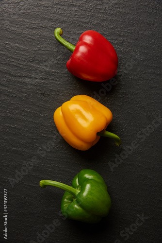vegetable concept three different colors of bell peppers lying on the dark background