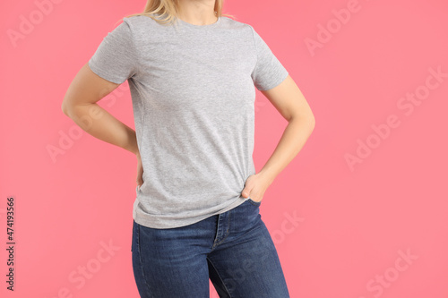 Woman in blank gray t-shirt on pink background
