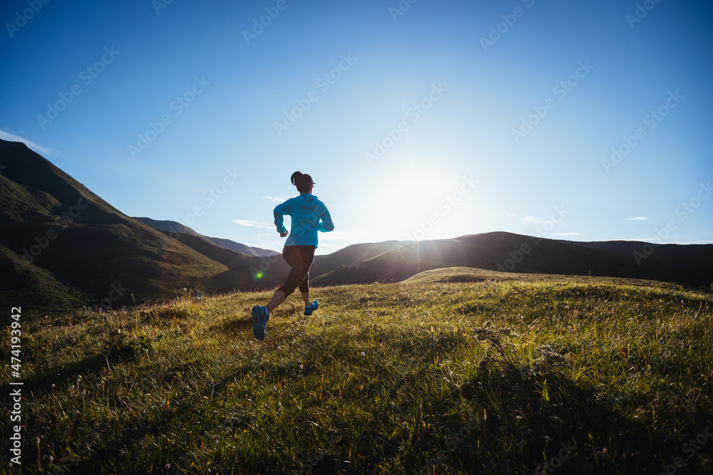 Woman ultramarathon runner running at mountain top