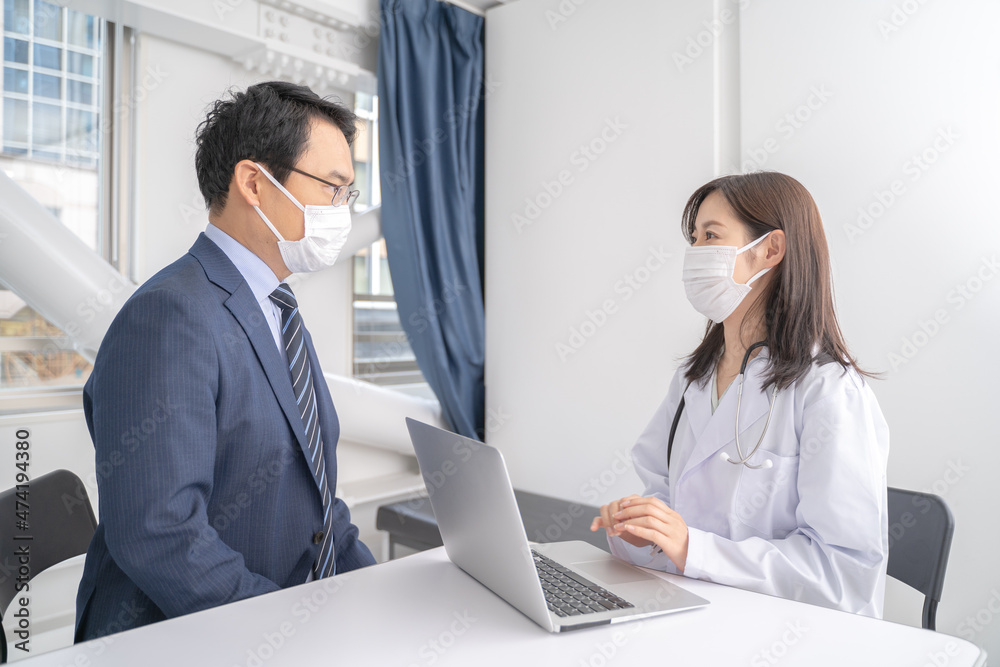 Fototapeta premium パソコンで診察する女医と男性患者メディカルイメージ