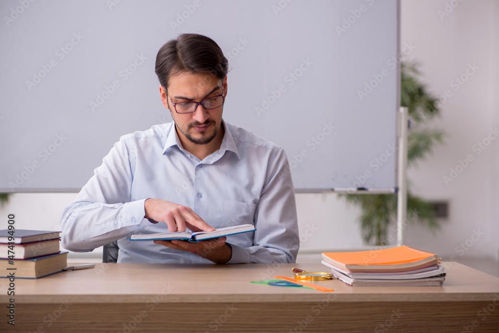 Young male teacher in front of whiteboard Young male teacher in front of whiteboard
