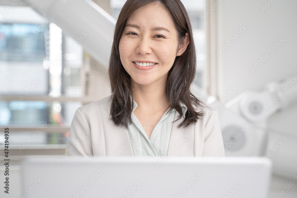 オフィスでノートパソコンで仕事をする女性のビジネスマン Stock Photo Adobe Stock