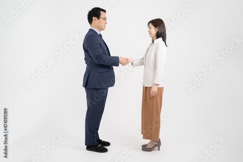 握手をする笑顔の男女のビジネスマンｰ全身引き白背景