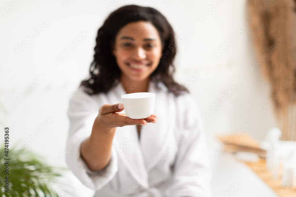 African American Lady Showing Cream Jar In Bathroom, Selective Focus African American Lady Showing Cream Jar In Bathroom, Selective Focus