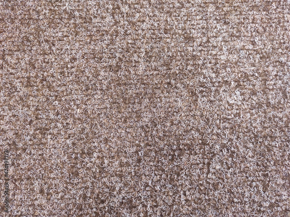 Fototapeta premium Close-up of brown carpet texture background indoors. Texture of brown carpet texture.