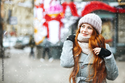 Lovely ginger lady walking at the city with snowflakes © vpavlyuk