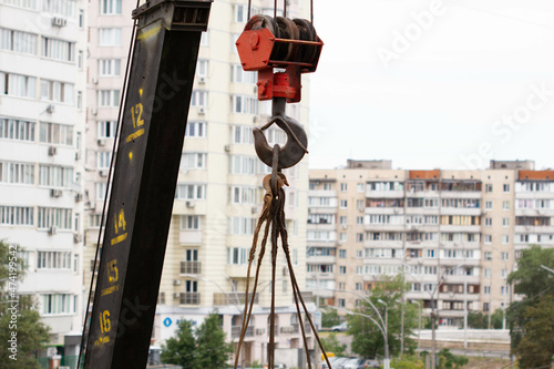 Crane hook. Tower Crane Hoist Rope against the blue sky and new building. Hawser of winch. Crane lifting cables. Construction site. Construction equipment. Close-Up