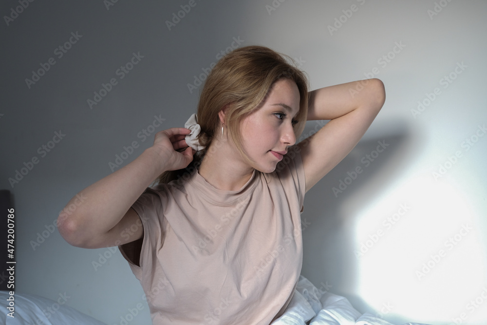 newly awakened woman sitting on her bed combing her hair, young beautiful woman sleeping sitting on the bed newly awakened woman sitting on her bed combing her hair, young beautiful woman sleeping sitting on the bed