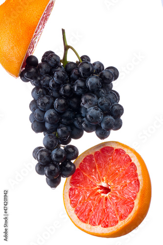 Dark blue grape with red grapefruit isolated on white background