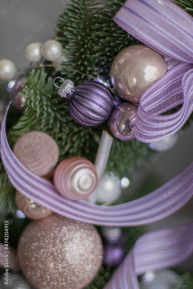 Beautiful details of festive wreath of fresh spruce. Christmas wreath with ornaments and balls in pink and purple color. Christmas mood. Beautiful details of festive wreath of fresh spruce. Christmas wreath with ornaments and balls in pink and purple color. Christmas mood.