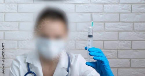 Medicine risk with injection. A view of a doctor hand in blue latex gloves with ingection in the room. photo