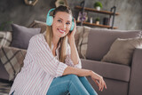 Profile side photo of young cheerful woman enjoy listen song headphones sit apartment quarantine indoors
