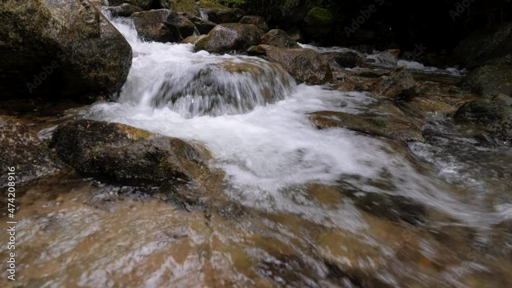 Detailed static shot of crystal clear mountain stream rocky waters flowing rapidly into the forest in 4K. Detailed static shot of crystal clear mountain stream rocky waters flowing rapidly into the forest in 4K.