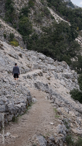 a man on the hiking trail to the Gola Gorropu in Urzulei, Sardinia, in the month of October