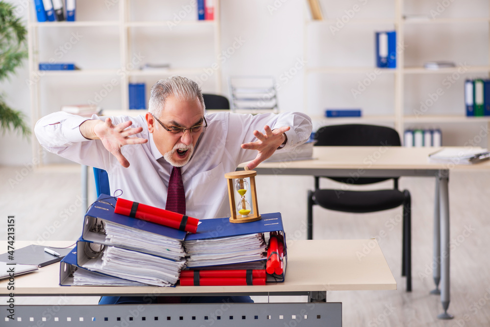 Old male employee with dynamite in the office Old male employee with dynamite in the office